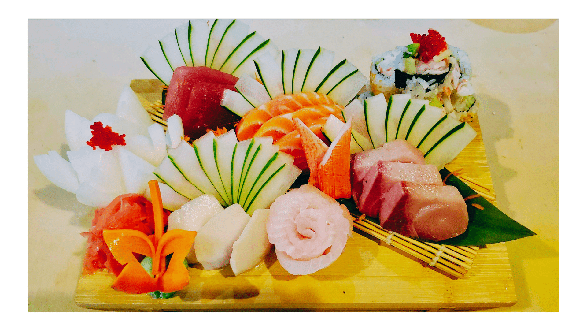 A beautifully arranged sushi platter with various types of sashimi and garnishes on a wooden board.